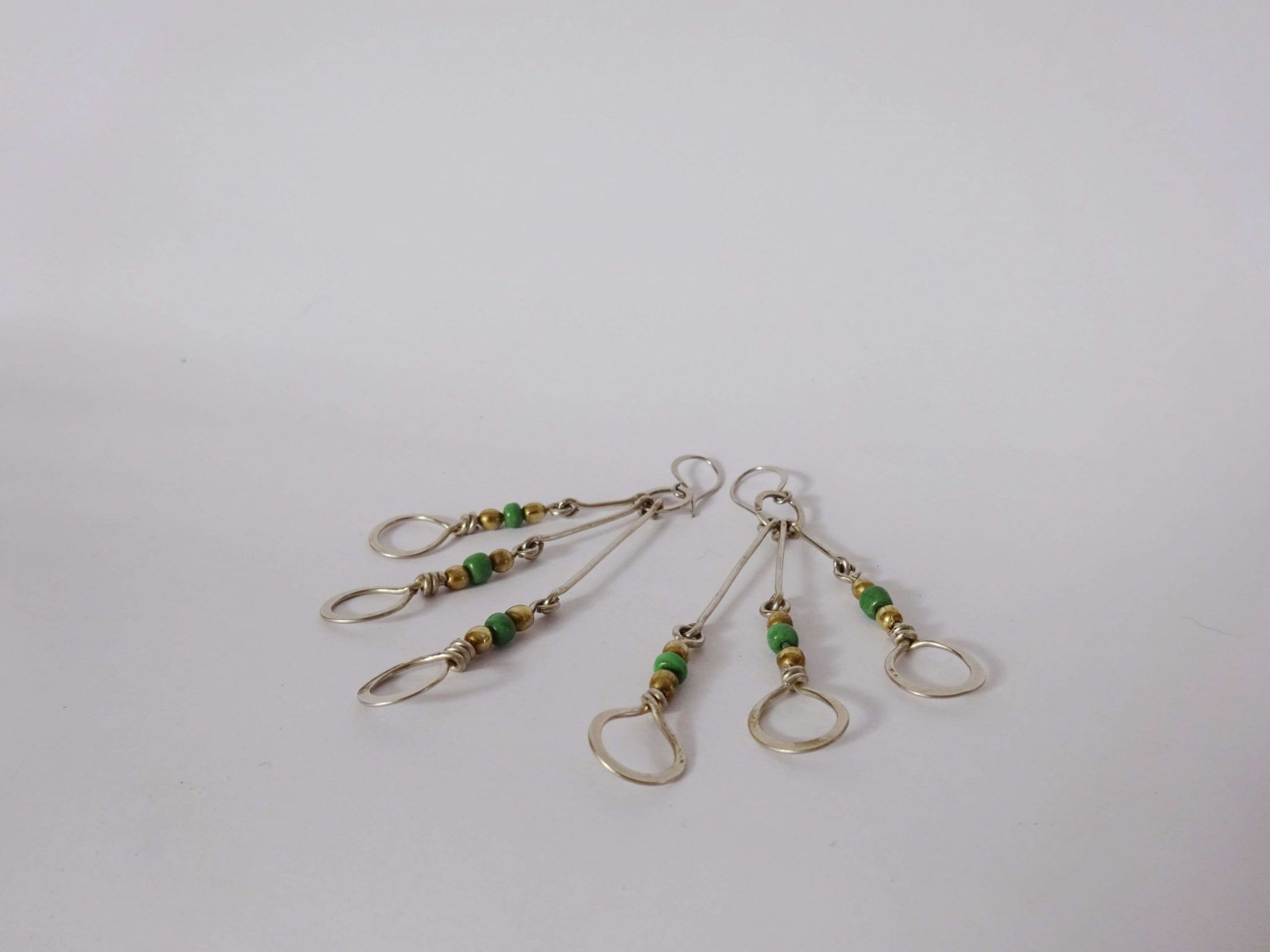pendientes alargados con circulos y piedra verde (8) pendientes plateados alargados con círculos, esferas y piedra verde